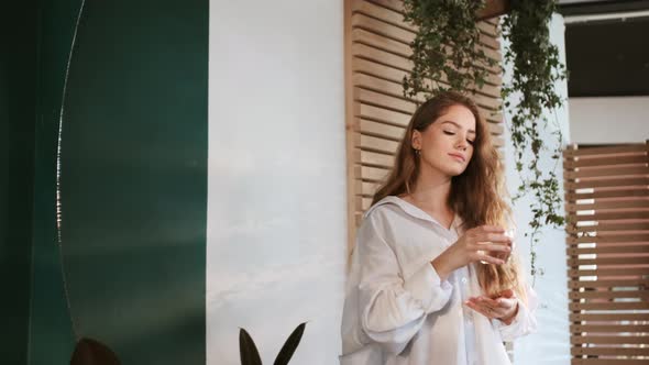 Young Red-Haired Girl Drinks Water.