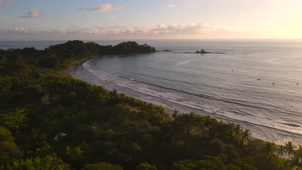 Aerial view of an uninhabited beach and forest at sunset in Costa Rica