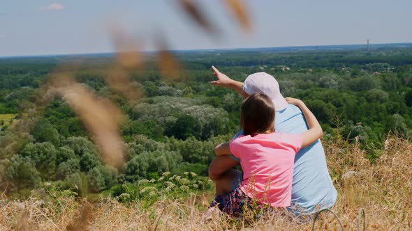 Beautiful Summer Landscape. Man and Little Girl, Dad and Daughter, Sit on Cliff Edge, Talking and