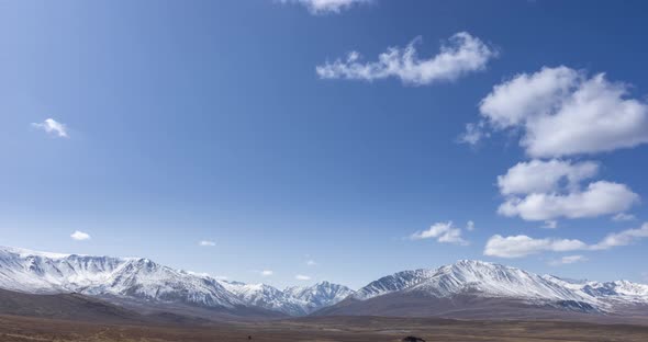 Timelapse of Sun Movement on Crystal Clear Sky with Clouds Over Snow Mountain Top