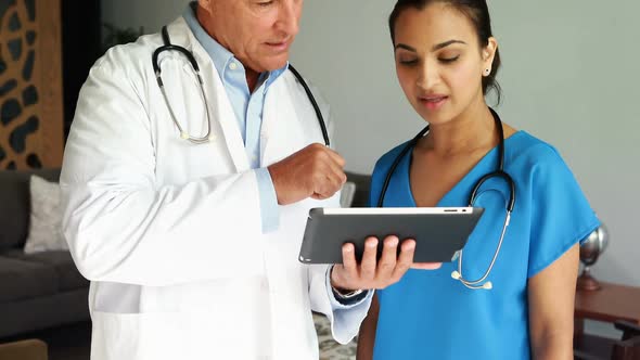 Doctors discussing over digital tablet