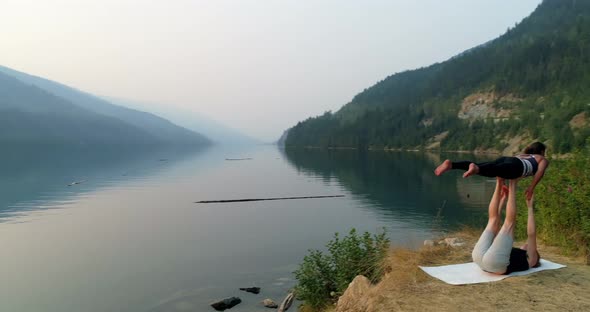 Women practicing acroyoga near lakeside 4k