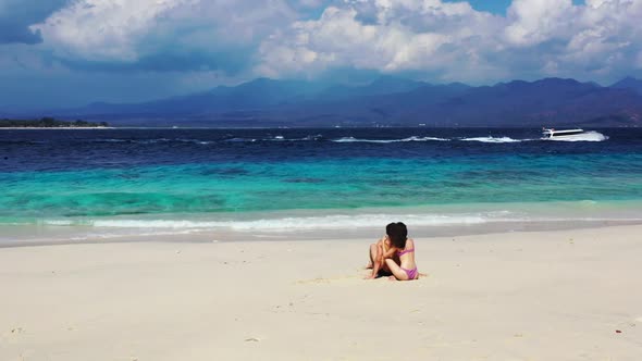 Two people happy together on perfect lagoon beach voyage by aqua blue sea and clean sand background 