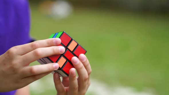 Close-up of rubik's cube in boy's hands. Boy is holding rubik cube and solving puzzle