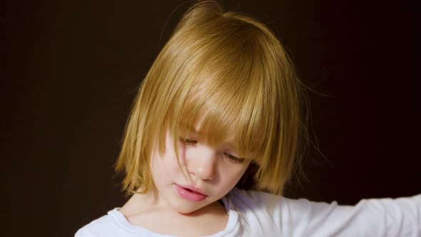 Studio portrait of a cute little blonde girl looking sad