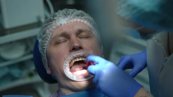 High Angle View of Caucasian Patient with Closed Eyes Sitting in Hospital As Dental Assistant