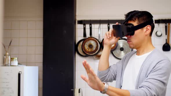 Man using virtual reality headset in kitchen