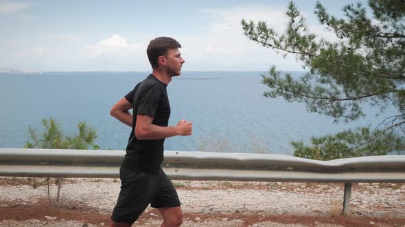 Athletic young man running on road