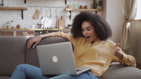 Surprised African American Lady Is Very Surprised Looking at Her Laptop. Quarantine Mode, Relaxing