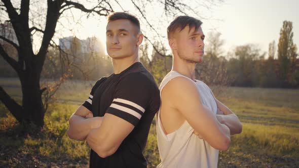 Two Young Caucasian Bodybuilders Standing in Sunlight and Looking at Camera. Handsome Strong