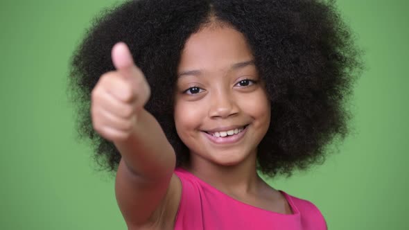 Young Cute African Girl with Afro Hair Giving Thumbs Up