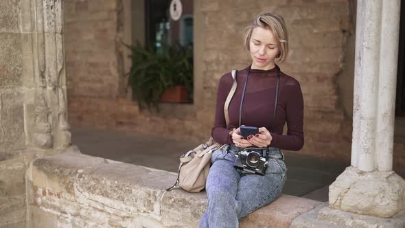 Female Woman Traveler with Camera Using Smartphone to Search Online Tourist Information in Ancient