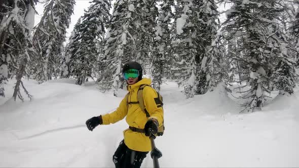 Professional snowboarder creating snow cloud riding on snowboard. Rider having fun doing tricks