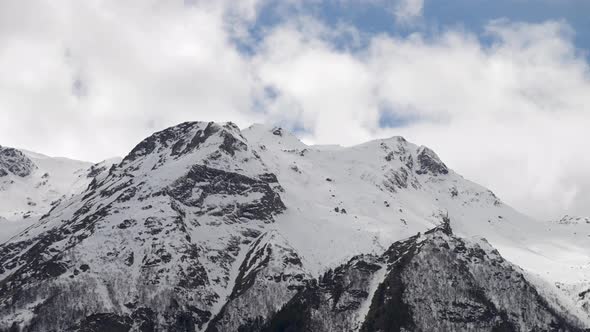 Timelapse Close-up of the Tops of Snow-capped Mountains on Which Clouds Float. Mountain Weather