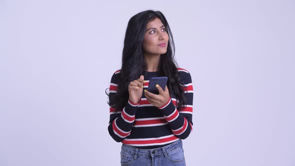 Happy Young Beautiful Persian Woman Thinking While Using Phone