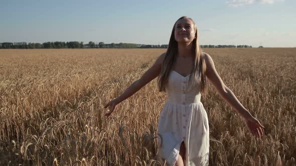 Pretty Smiling Woman Relaxing in Wheat Field