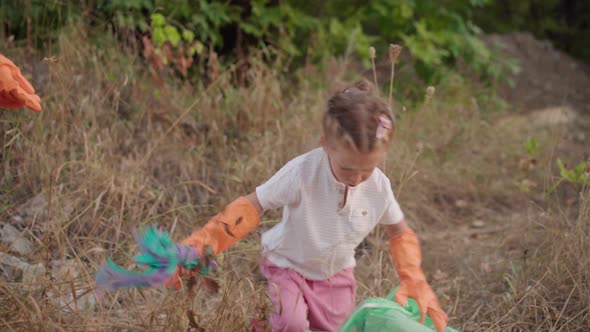 Little Girl Helps Mother Collects Plastic Garbage on Nature to Save Environment From Pollution