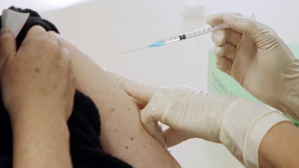 Paramedic giving people the COVID-19 vaccine injection during the vaccination operation