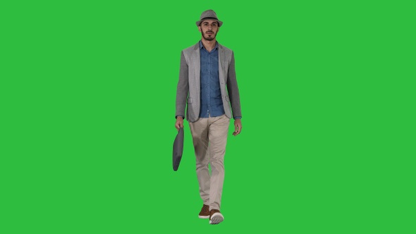 Casual arabian man walking in a hat and with a briefcase