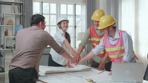 Engineers With Helmets And A Man Celebrating Finish Drawing Building Construction While Working