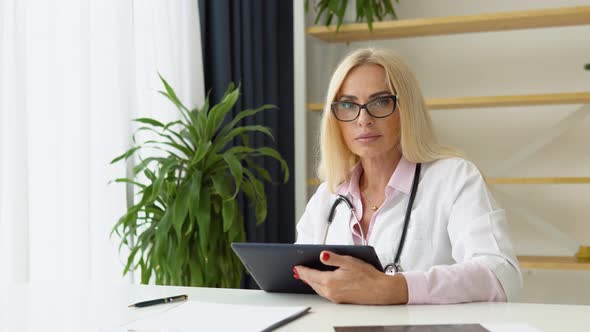 Smiling Female Physician with Tablet Posing in Hospital Office