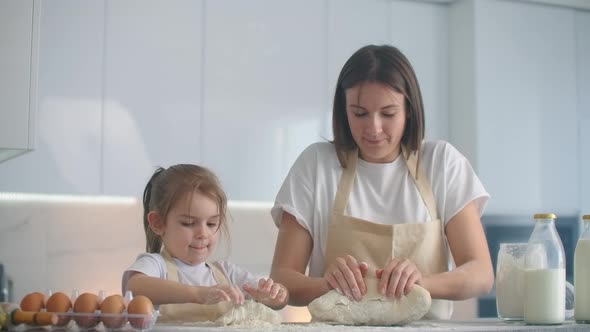 Mother and Daughter Cooking with Dough Mold in Kitchen. Mother and Daughter Holding Heart-shaped