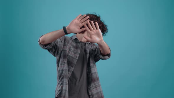 Dissatisfied Young Man with His Hands in Front Shows the Gesture of Refusal