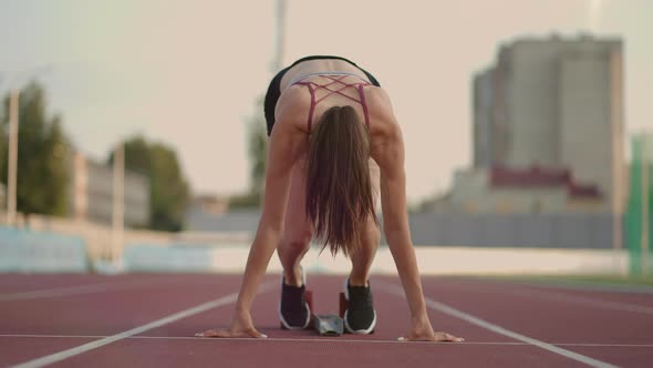 Caucasian Young Brunette Woman Shit for a Run in the Stadium Comes Up to the Running Sides and