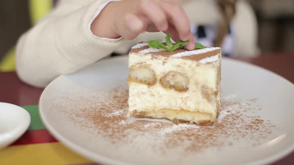 A charming little girl who eats a fresh sweet chocolate pie.