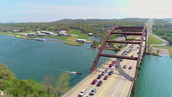 Bumper to bumper car traffic on the Pennybacker bridge with a view of Austin, Texas in the upper lef