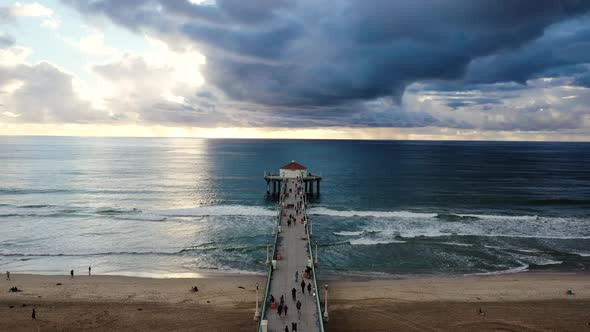 Aerial view of Manhattan Beach Pier and Pacific Ocean with stormy grey clouds