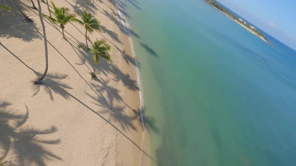 Fpv flight over tropical Playa Nueva Romana Beach with Caribbean Sea during sunny day - Boats anchor