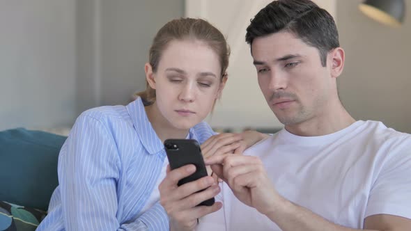 Young Couple in Shock While Using Smartphone