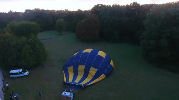 Air Balloon Envelope Getting Inflated on Ground, Sun Rising on Horizon, Aerial