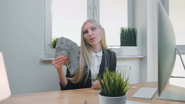 Relaxed Woman with Money in Office. Elegant Young Blond Female in Business Suit Sitting at Desk with