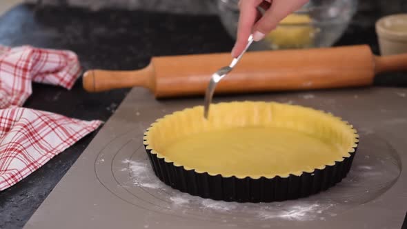 Woman Making French Tart in the Kitchen, Prick the Dough with a Fork