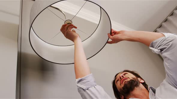 Man installing a bulb in living room