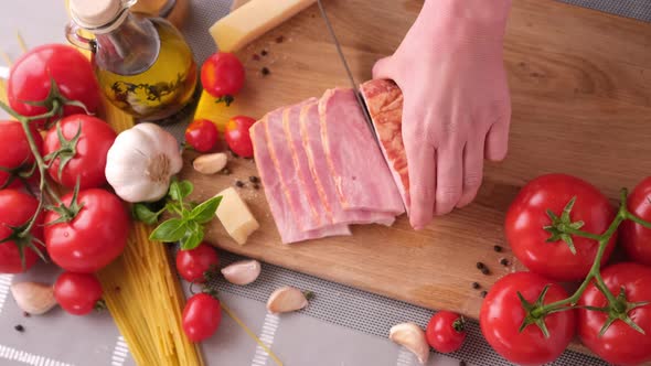 Making Pasta Carbonara Slicing Traditional Pancetta Bacon Into Pieces on a Wooden Cutting Board with