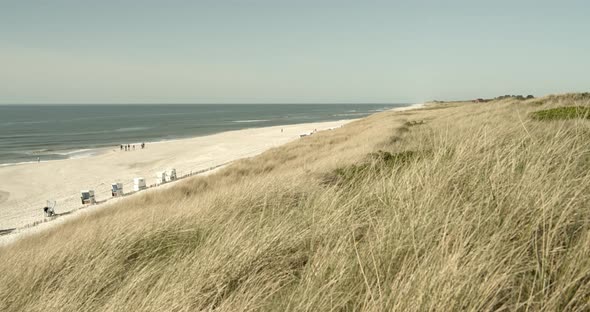Wide angel shot of the beach and the dunes of Sylt with the Northsea in the background 4k 60fps