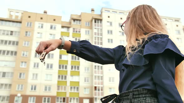 A Young Schoolgirl Holds the Keys to a New Apartment