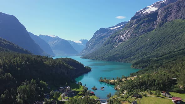 Spectacular view of Loen turquoise glacier water among epic mountain scenery with deep valley and sn