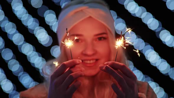 Girl with Sparklers on the Background of the Christmas Lights of the Evening City