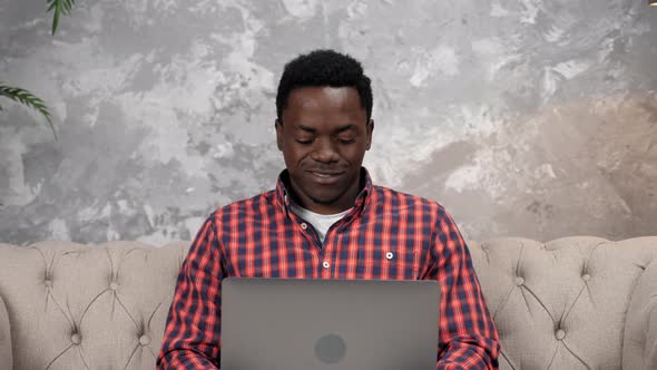 Smiling African American Businessman Works for Laptop Chatting with Employees