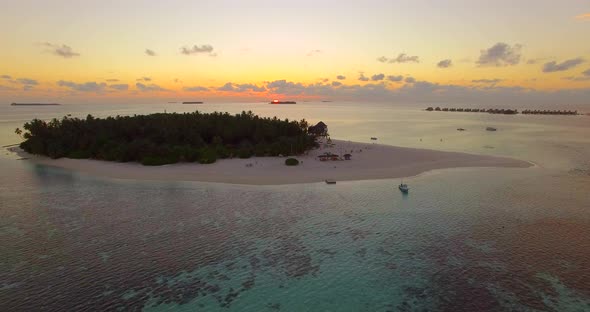 Aerial drone view of a scenic tropical island in the Maldives at sunset