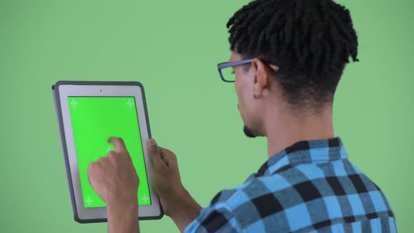 Closeup Rear View of Happy Young African Hipster Man Using Digital Tablet