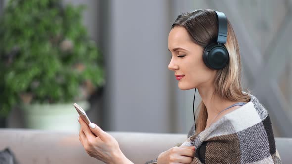 Smiling Girl Listening Music in Headphones Use Smartphone