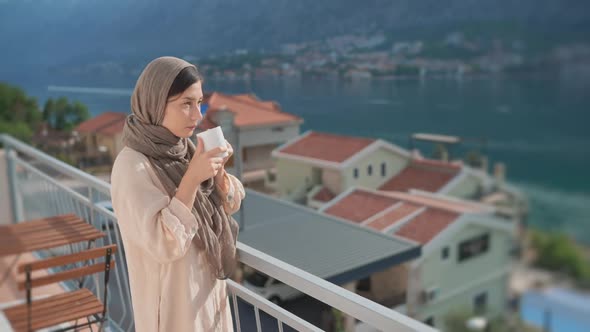 Woman Traditional Arab Dress Stands Terrace Enjoying Drinking Hot Coffee Tea Watching Views of