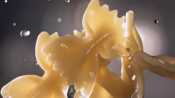 Pasta Farfalle is Flying Up on a Kitchen Bokeh Background