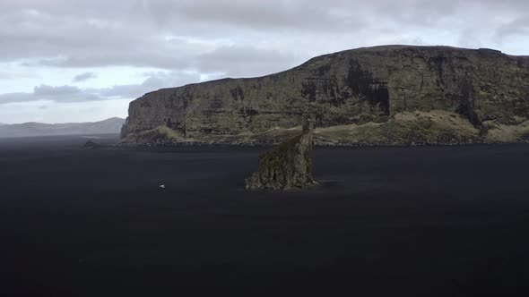 Aerial Shot of Sea Stack and Tall Cliff Seen in the Background