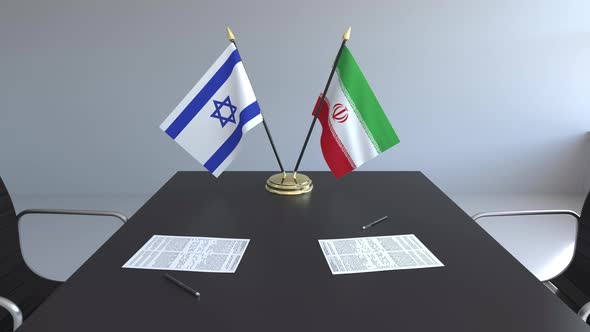 Flags of Israel and Iran and Papers on the Table